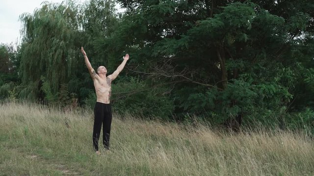 The modern cossack looks on the sky and raising hands 4K