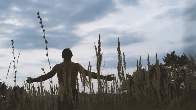 Portrait of the modern cossack looks on the sky and raising hands 4K