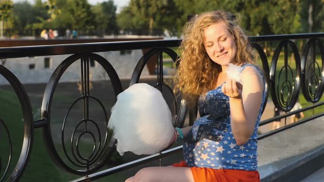 on the nature of the pregnant woman holding a white cotton candy
