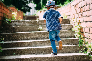 a little boy runs up the stairs - 179480172