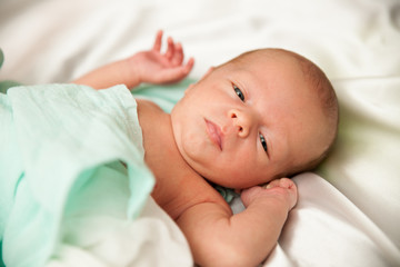 Newborn child lying on bed