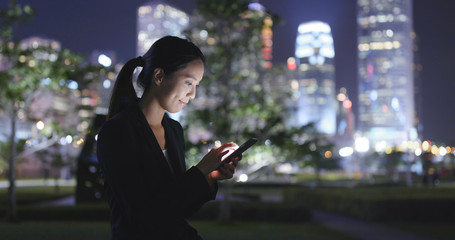 Business woman working on mobile phone at night