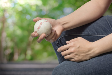 Hand holding a baseball on nature background