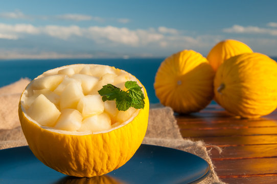 Typical mediterranean fruits: yellow melon with blue sea in the background