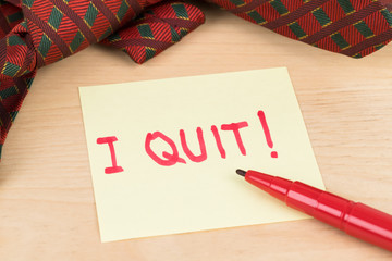 Resign quit notice on sticky note with necktie and pen