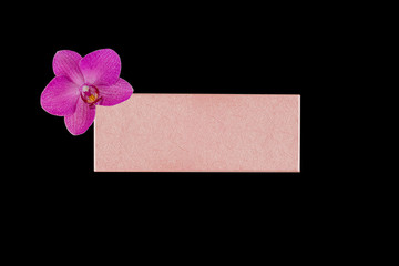 Pink gift box with purple Orchid flower, isolated on black background, top view mock up