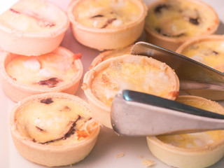 Closeup egg tarts with silver tong