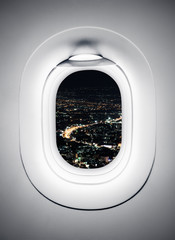 Obraz premium Night city at airplane window