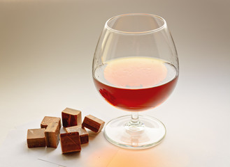 Cognac with dark chocolate on white background