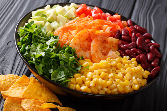 Mexican snack: burrito bowl with shrimp and vegetables close-up. horizontal
