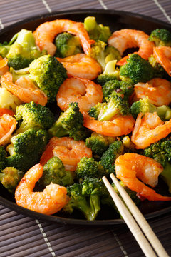 Freshly cooked prawns with broccoli close-up. vertical