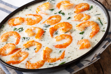 Tiger prawns with spinach and garlic in creamy cheese sauce close-up on a plate. horizontal