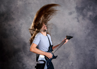 wild musician with black guitar and flying hair