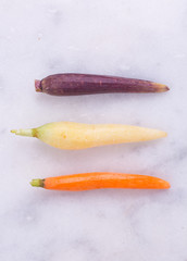 Heirloom rainbow carrots. Marble tabletop. Copy space