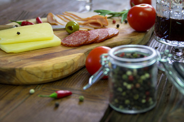 Appetizer on a wooden board. With wine and olives  