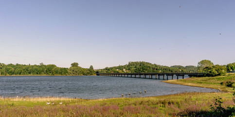Panoramic view of a lake and its shores formed by the Cecebre reservoir in Galicia (Spain). On the right the bridge that crosses it looks