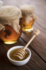 Honey and wooden stick are on a table
