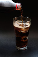 Pour bottle of cola soda on black background or pour cola isolated use for food and drink background