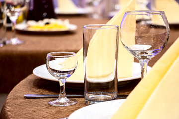 The table in the restaurant. On the table there are empty wine glasses, napkins and a plate