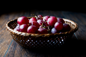 Purple Grapes in wooden basket. Dark Moody