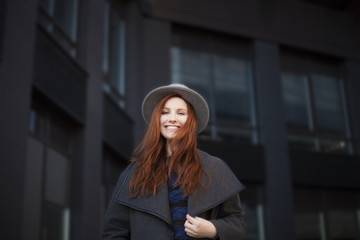 Outdoor portrait. Young stylish beautiful woman in hat while walking in the big city streets.