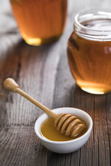Honey and wooden stick are on a table