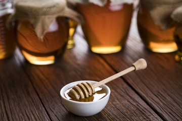 Honey and wooden stick are on a table