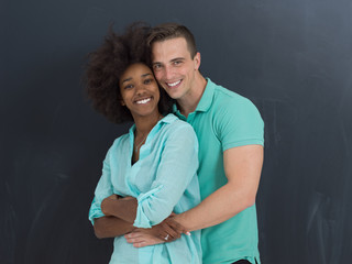 multiethnic couple in front of gray chalkboard