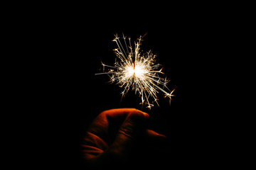 Light sparkles Bengal lights on a black background isolated