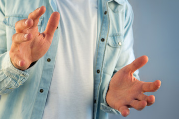 Young man giving an empty hand on a color background