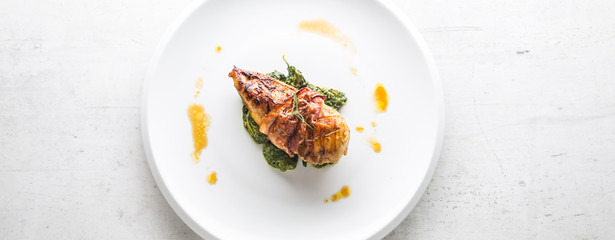Chicken grill breast. Chicken roasted breast with bacon and spinach on whitew plate