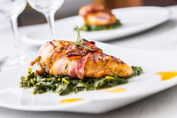 Chicken grill breast. Chicken roasted breast with bacon and spinach on white plate. Culinary food  in hotel pub or restaurant