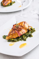 Chicken grill breast. Chicken roasted breast with bacon and spinach on white plate. Culinary food  in hotel pub or restaurant