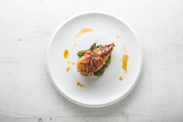 Chicken grill breast. Chicken roasted breast with bacon and spinach on whitew plate