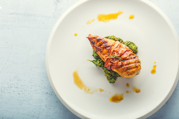 Chicken grill breast. Chicken roasted breast with bacon and spinach on whitew plate