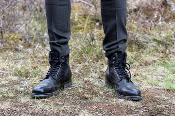 Br&auml;utigam steht in schwarzen Boots im Gras