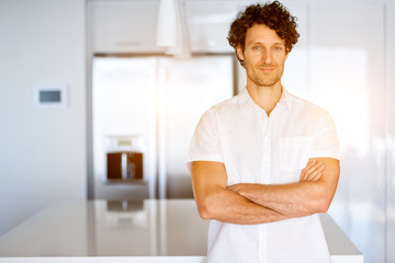 Portrait of a smart young man standing in kitchen