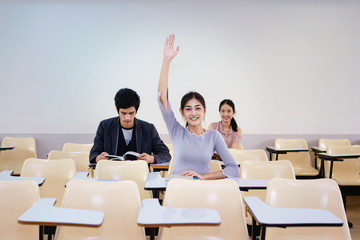 Adult students with hands up at class