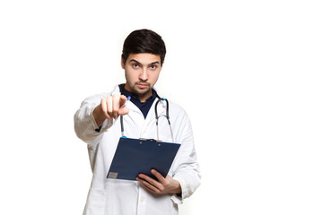 beautiful young doctor in a dressing gown with a stethoscope on a white background in the studio, records a medical history,