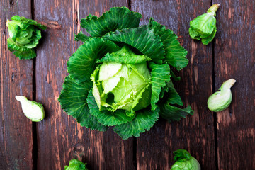 Fresh green cabbage big and small on wooden background. Top view. Copy space. Flat lay.