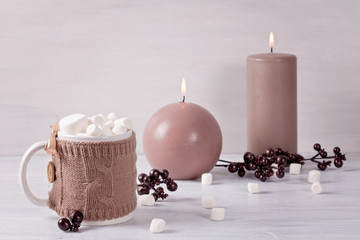 Hot chocolate drink with marshmallows and candles for cold weather. Christmas celebration or cold winter concept with copy space