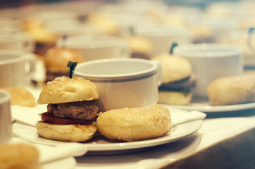 Blurred for background.Coffee break at conference meeting for seminar.Doughnut,Hamburger and white cup of coffee.Concept for blur background.