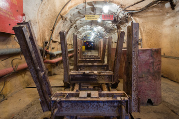 Underground emerald ore mine shaft tunnel gallery passage with light and ore cart 
