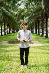 Young asian man photographer holding retro camera in park