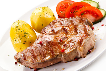 Grilled steak with vegetables on white background