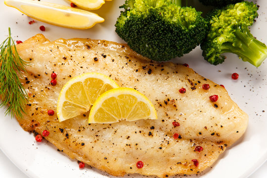 Fried fish fillet with broccoli on white background