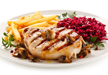 Grilled steak, French fries and vegetables on white background