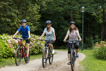 Healthy lifestyle - people riding bicycles in city park