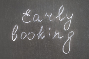 Text Early Booking handwritten with white chalk on a blackboard. banner for sale offer.