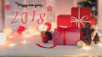 Christmas and New Year holidays gift box with decorative ornament on white wooden table with falling snow effect.New Year 2018 sign background.Gifts and congratulations concept.